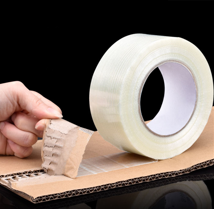 Uni-directional filament tape securing heavy cartons and industrial bundles